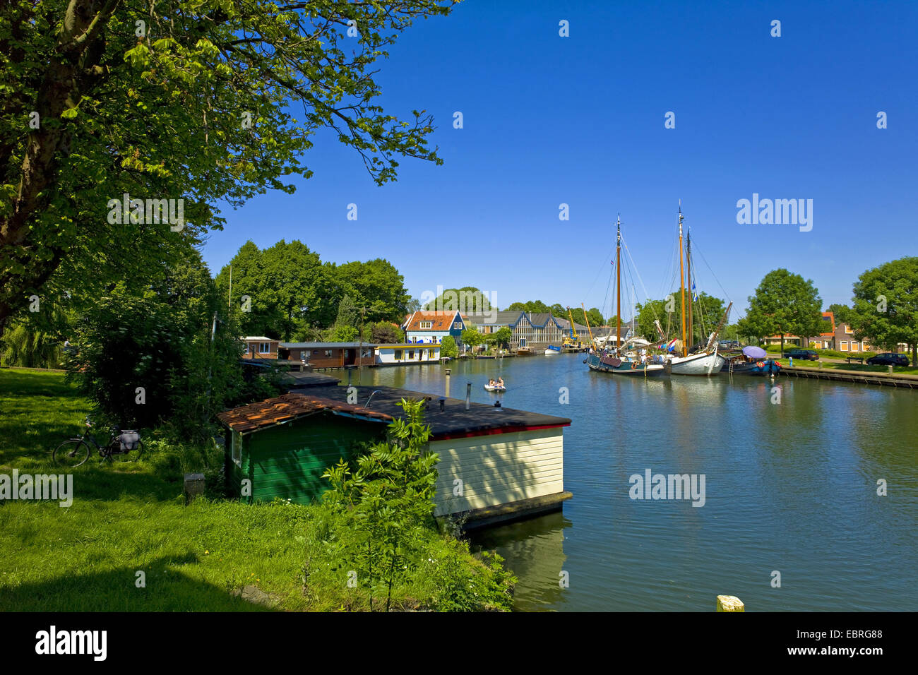 A fondo piatto di navi a vela e barche casa su un canale, Paesi Bassi, Noord Holland, Volendam Foto Stock