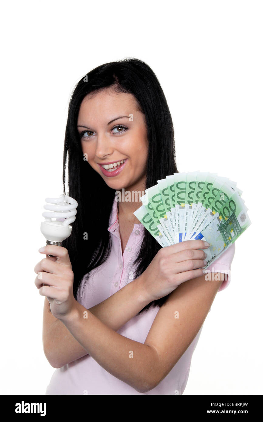 Donna con il risparmio energetico lampada e . Lampada a risparmio energetico e moneta Foto Stock