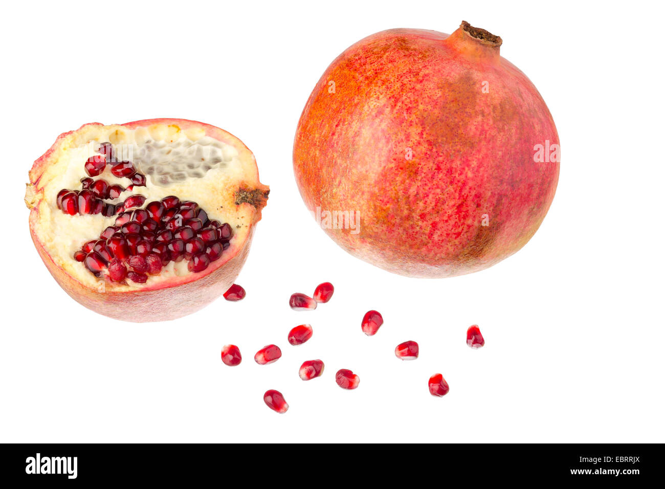 Una intera e una mezza melograni con semi. Foto Stock