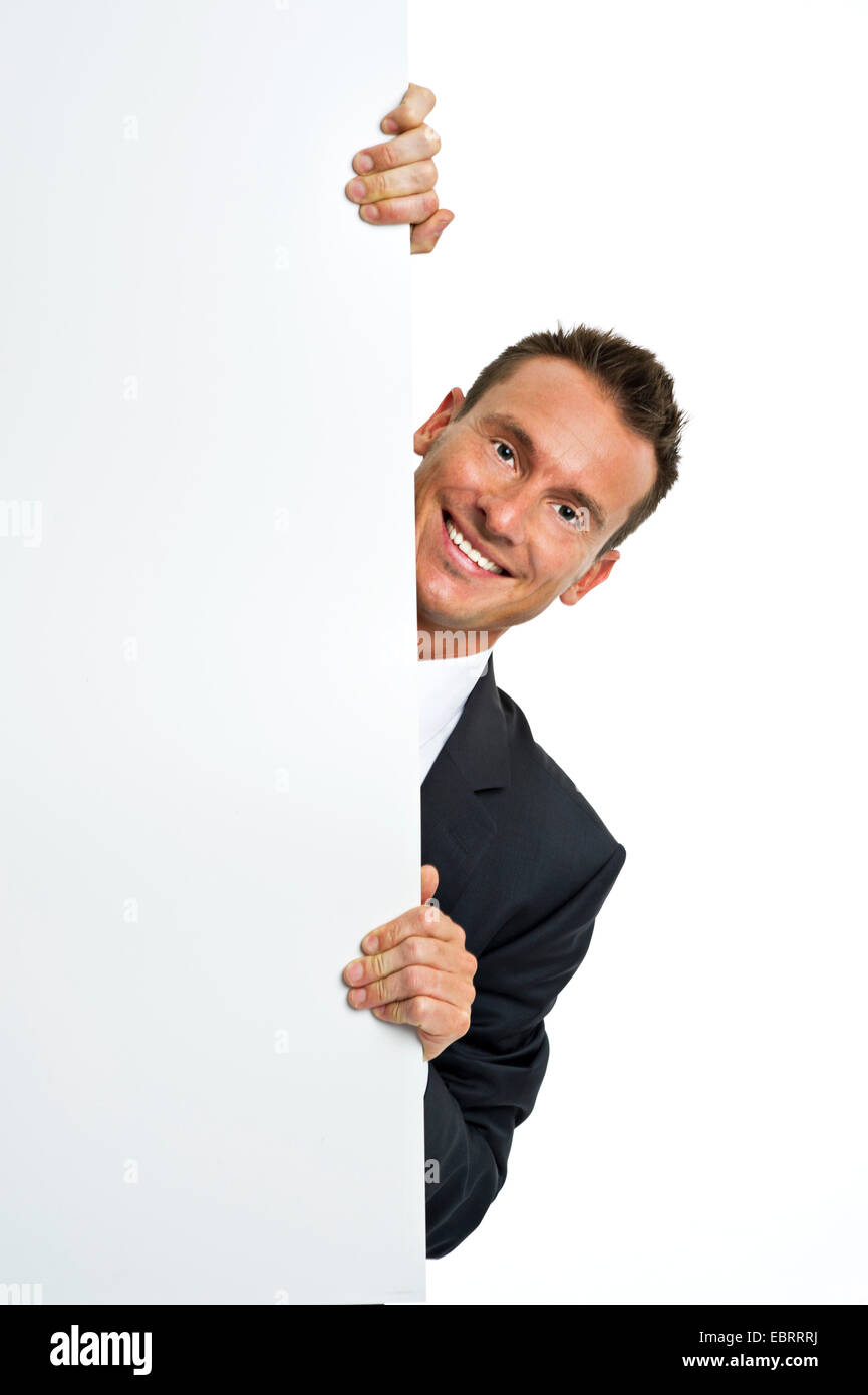 Affascinante uomo orgogliosamente in tuta è il peering dietro uno spazio vuoto Foto Stock