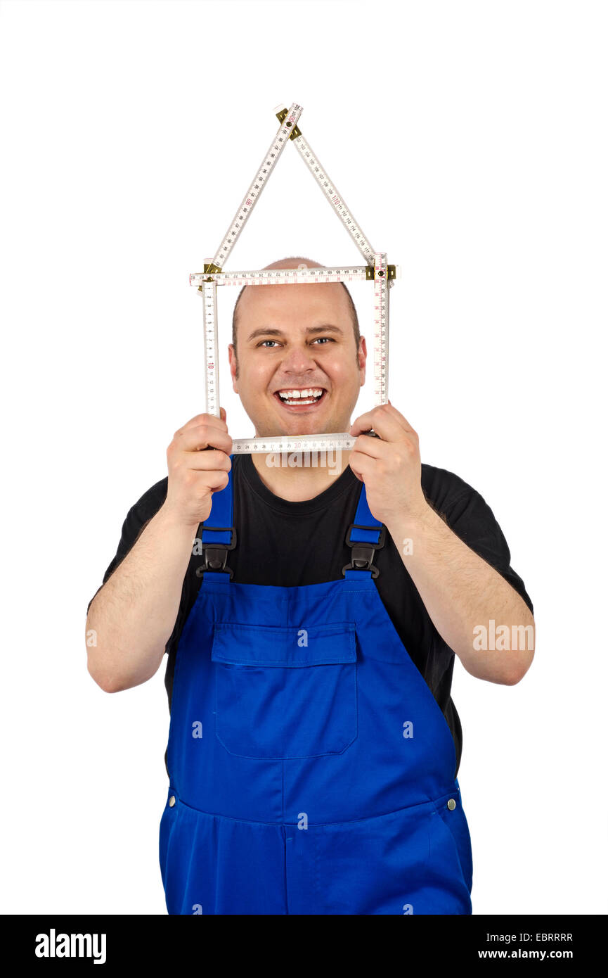 Artigiano che mostra una regola pieghevole nella forma di una casa Foto Stock