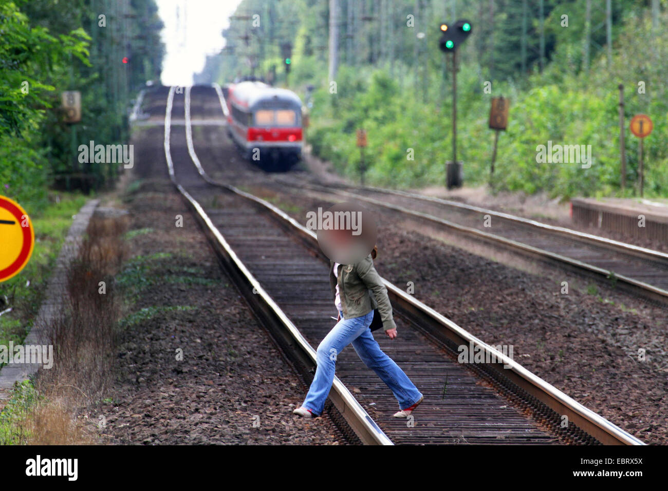 Donna attraversando la ferrovia area, pericolo di vita, Germania Foto Stock