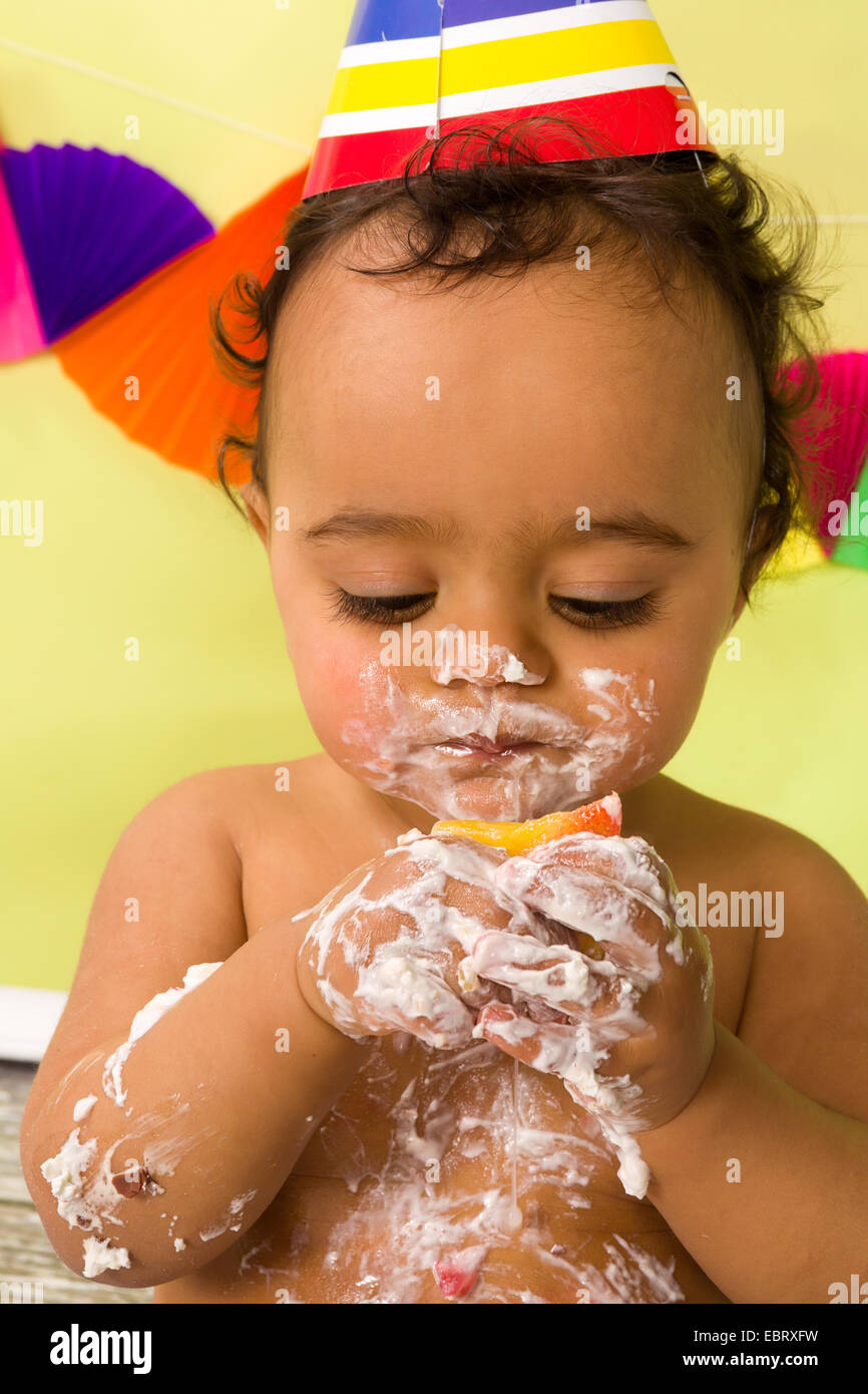 Adorabile bambino africano durante una torta smash del suo primo compleanno Foto Stock