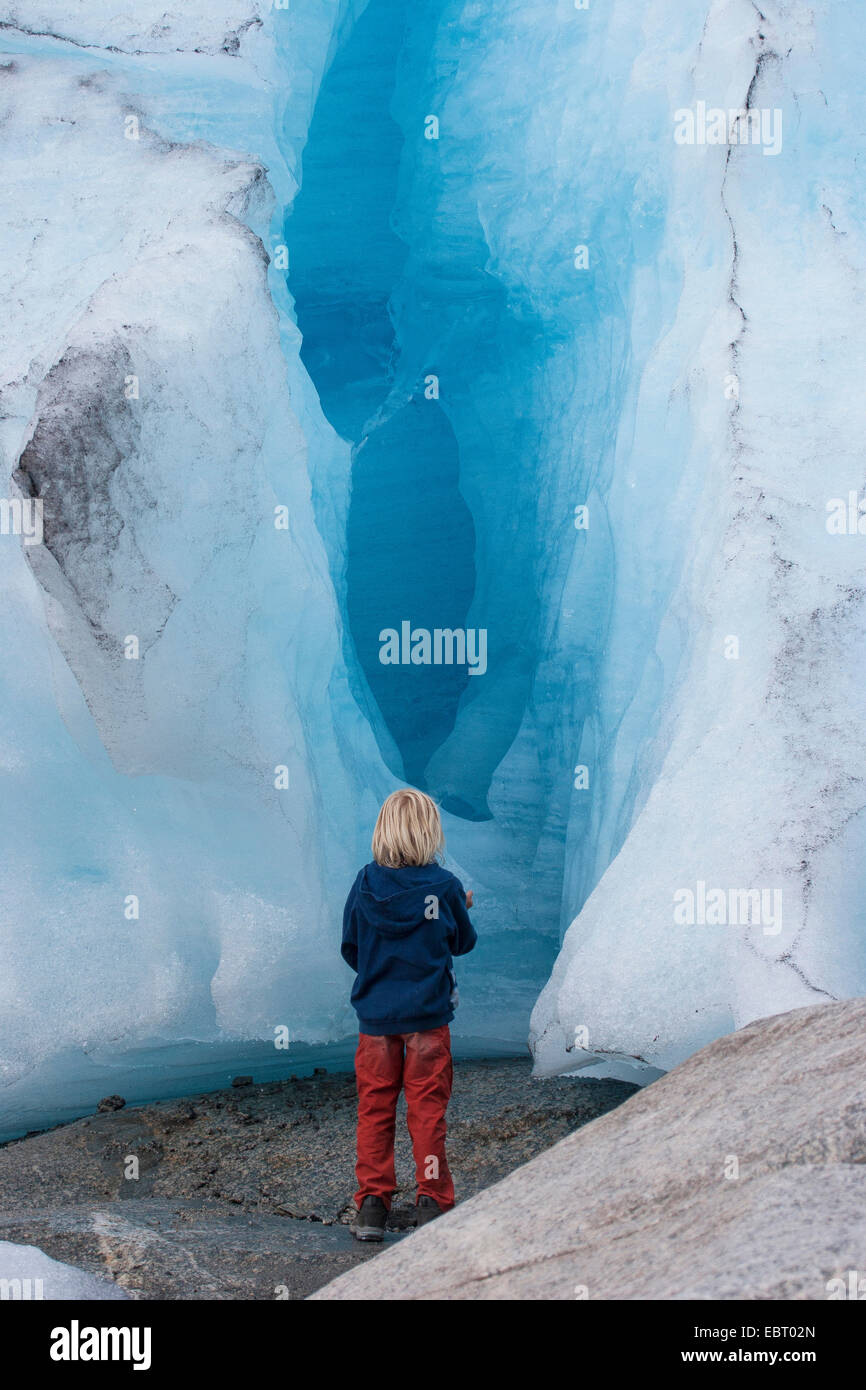 Bambino in piedi presso il ghiacciaio Nigardsbreen, Norvegia, Jostedalsbreen Parco Nazionale Foto Stock