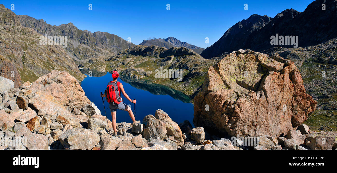 Escursionista femmina in piedi presso il Lac du basto sul lago di montagna e godere la bella vista, Francia, Alpes Maritimes, il Parco Nazionale del Mercantour, Belvedere Saint Marin de Vesubie Foto Stock
