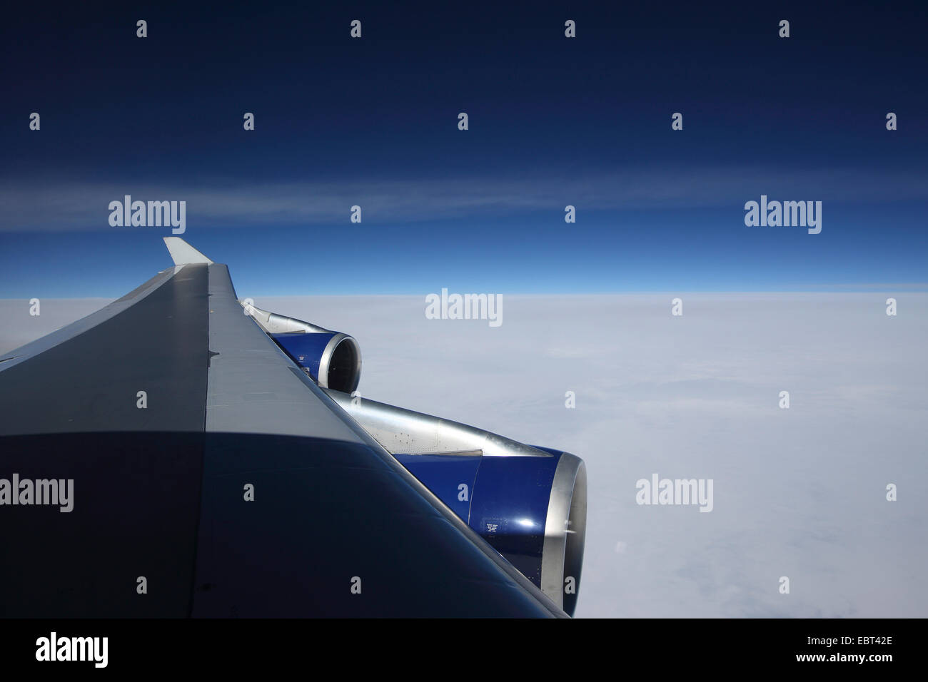 Vista attraverso un'ala di aereo Boeing 747 per le nuvole e il cielo Foto Stock