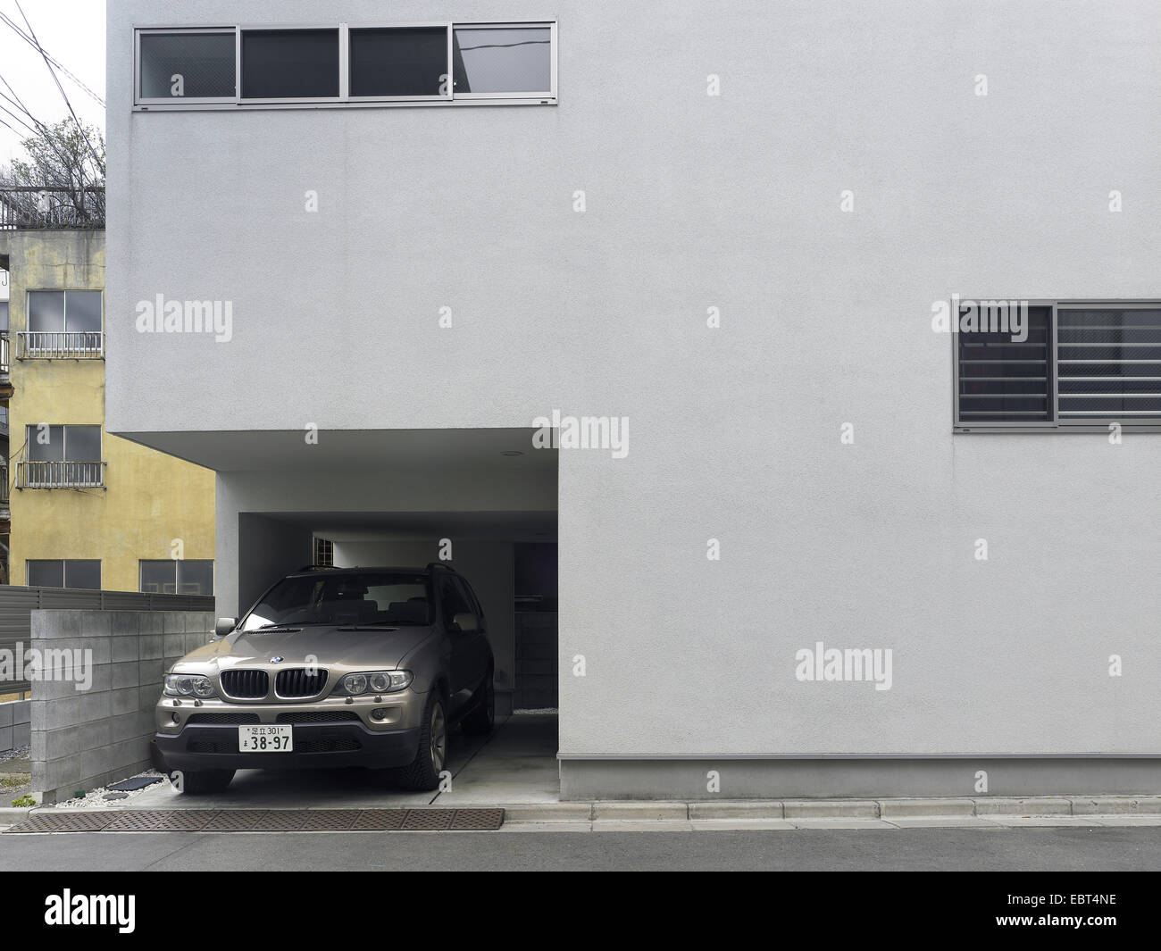 Privato edificio contemporaneo in una strada giapponese, con una Bmw auto parcheggiata. Tokyo Foto Stock