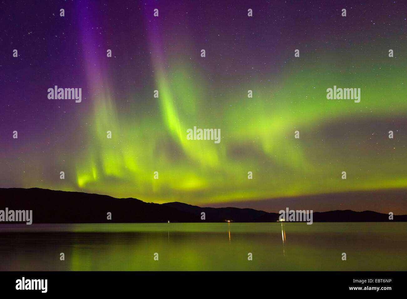 Luce polare con bandiere viola mirroring in un fiordo, Norvegia Namsos Foto Stock