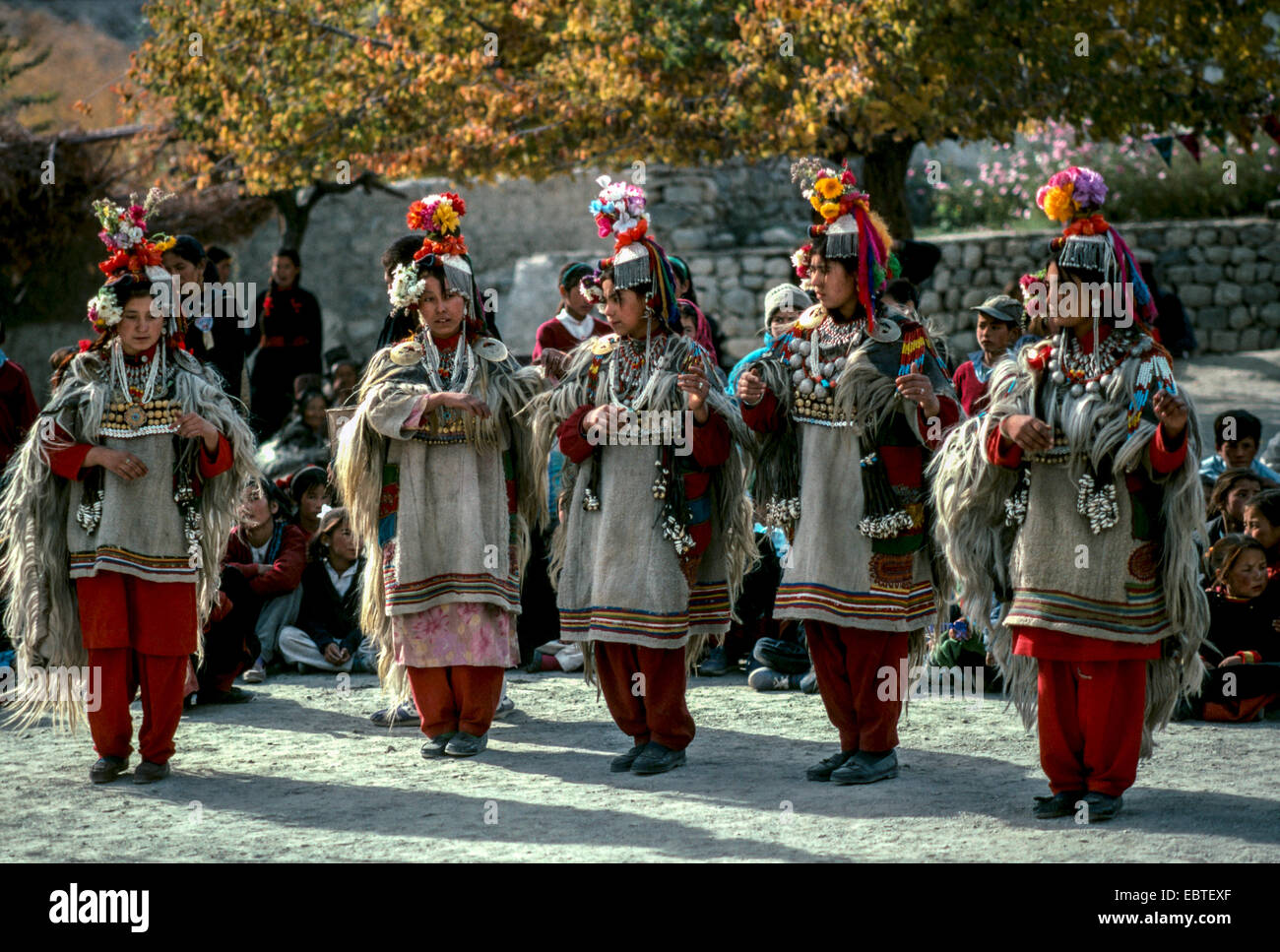 Ladakh Tibet tribù Nubra Donne che cantano costume tradizionale abito di testa di pelle di capra mantello pom pom testa permanente di ingranaggio di sole alberi Foto Stock