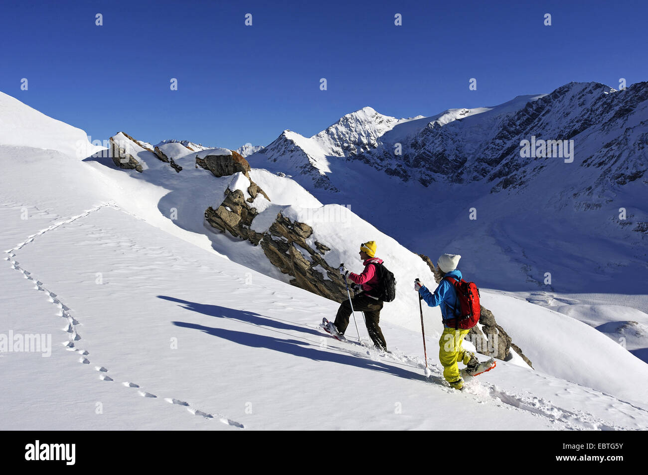 Due ragazze adolescenti con le racchette da neve in montagna innevata del paesaggio, Francia, Savoie, Sainte Foy Tarentaise Foto Stock