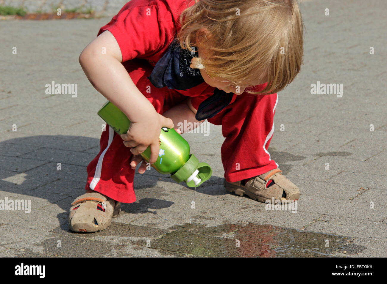 Tre-anno-vecchio ragazzo giocando con la sua borraccia, Germania Foto Stock