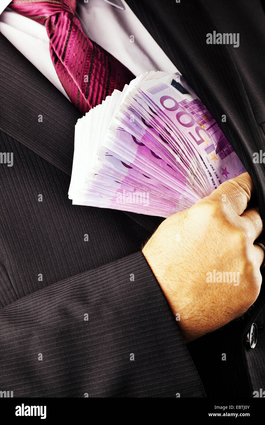 Uomo d'affari mettendo un batuffolo di 500 Euro Bills nella sua giacca Foto Stock
