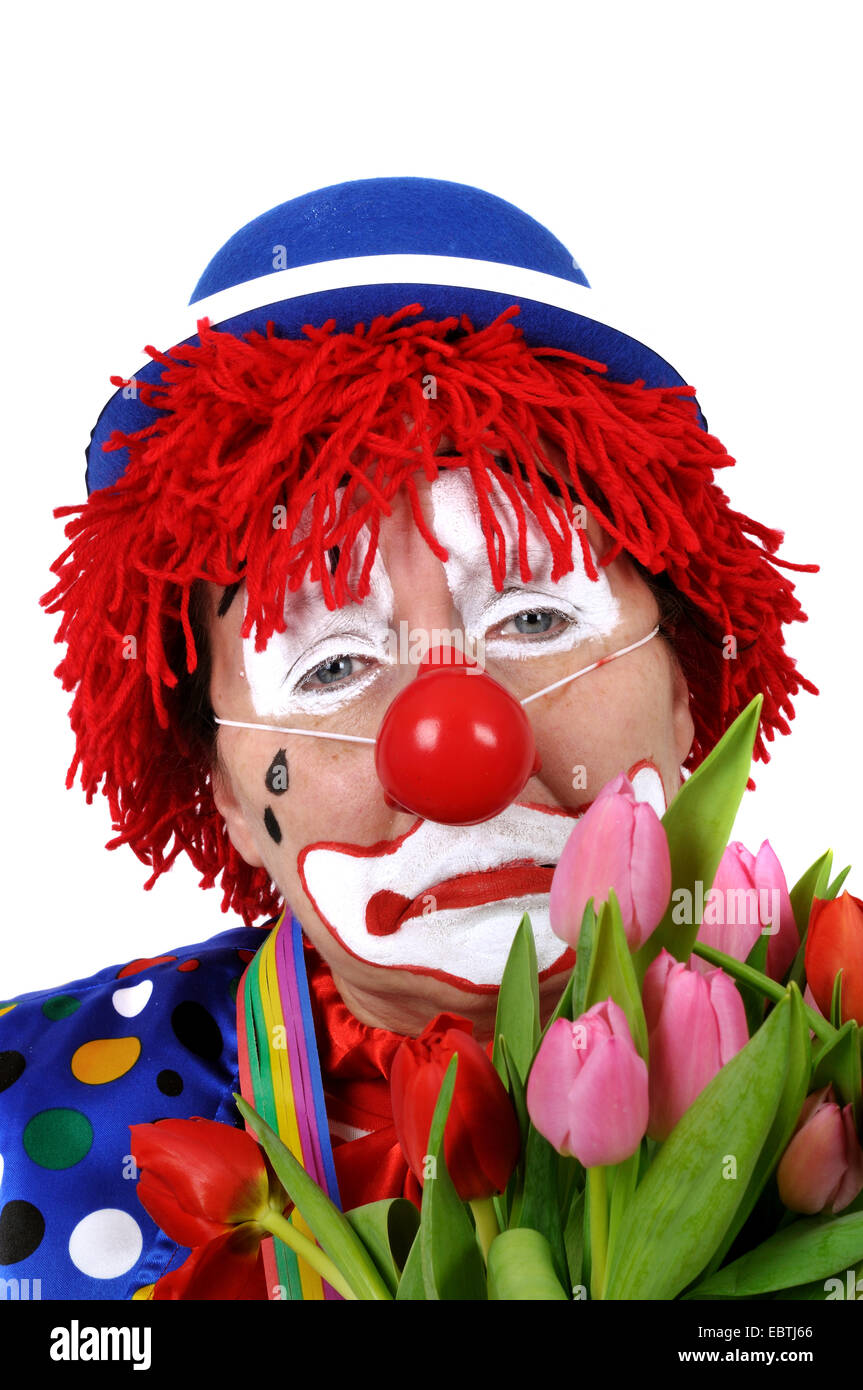 Triste clown con un mazzo di tulipani Foto Stock