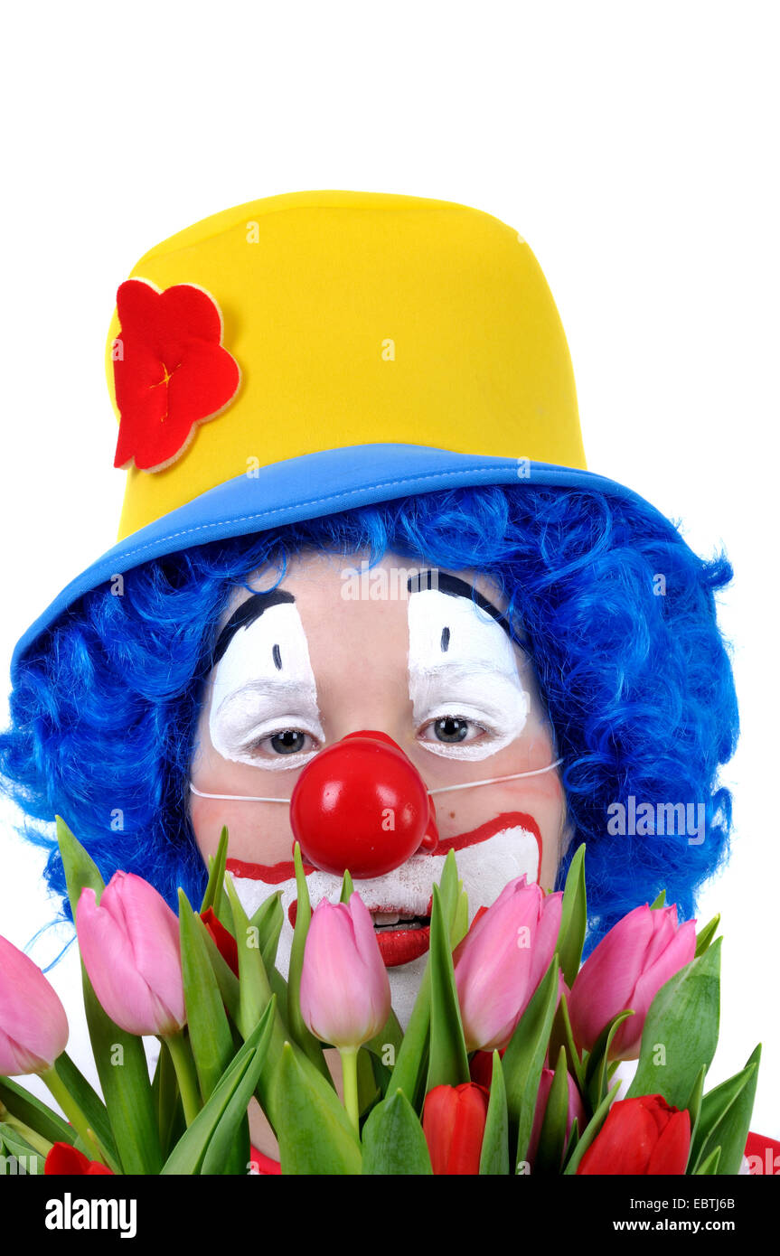 Little Boy vestito come clown tenendo un mazzo di fiori Foto Stock
