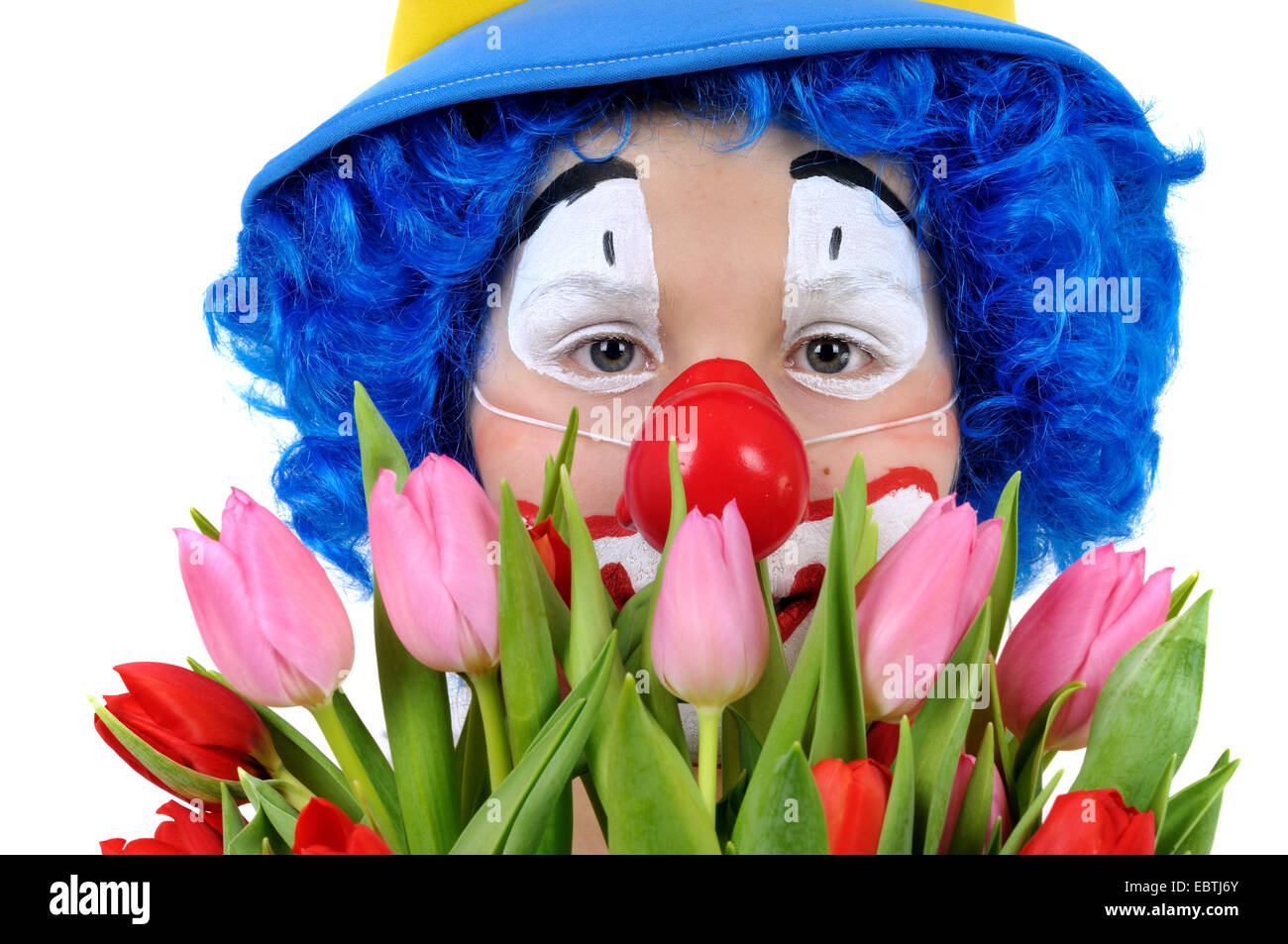 Little Boy vestito come clown tenendo un mazzo di fiori Foto Stock