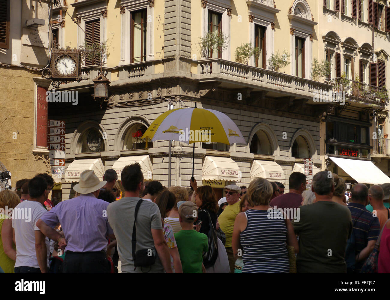 Un gruppo di tour in piedi in una piazza di Firenze, Italia Foto Stock