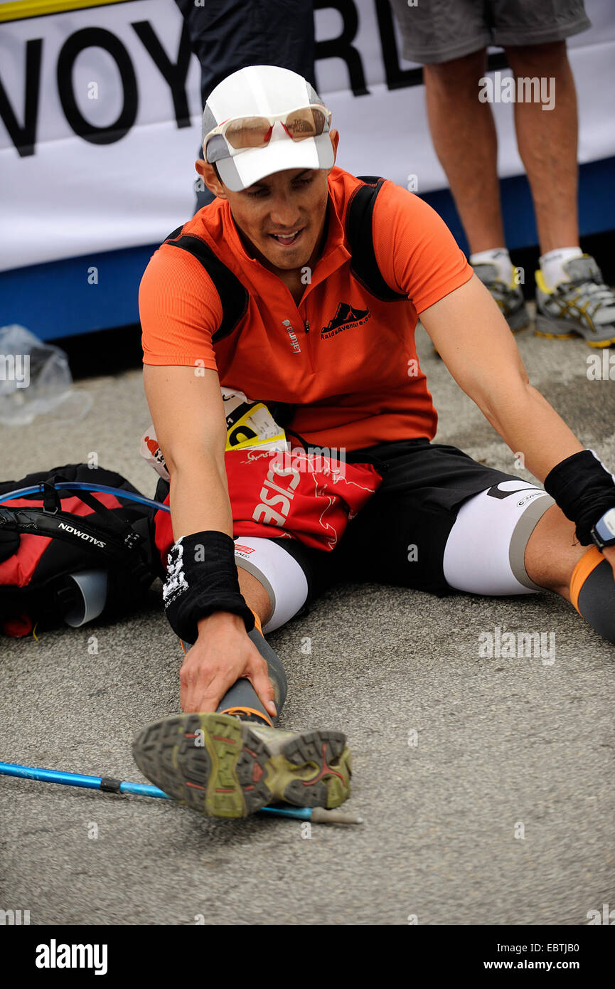 Esaurito runner seduto a terra, Francia, Savoie Foto Stock
