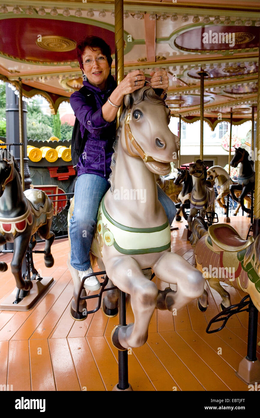 Donna su una giostra cavallo, Germania Foto Stock