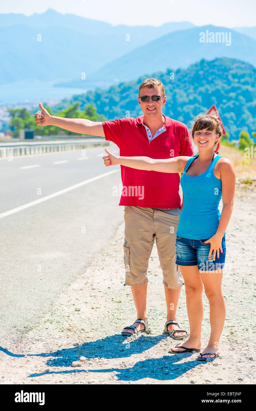 Coppia di giovani turisti allegro autostop Foto Stock