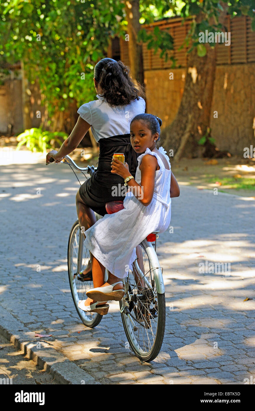 Due ragazze in bicicletta assieme su una bici, Seicelle Foto Stock
