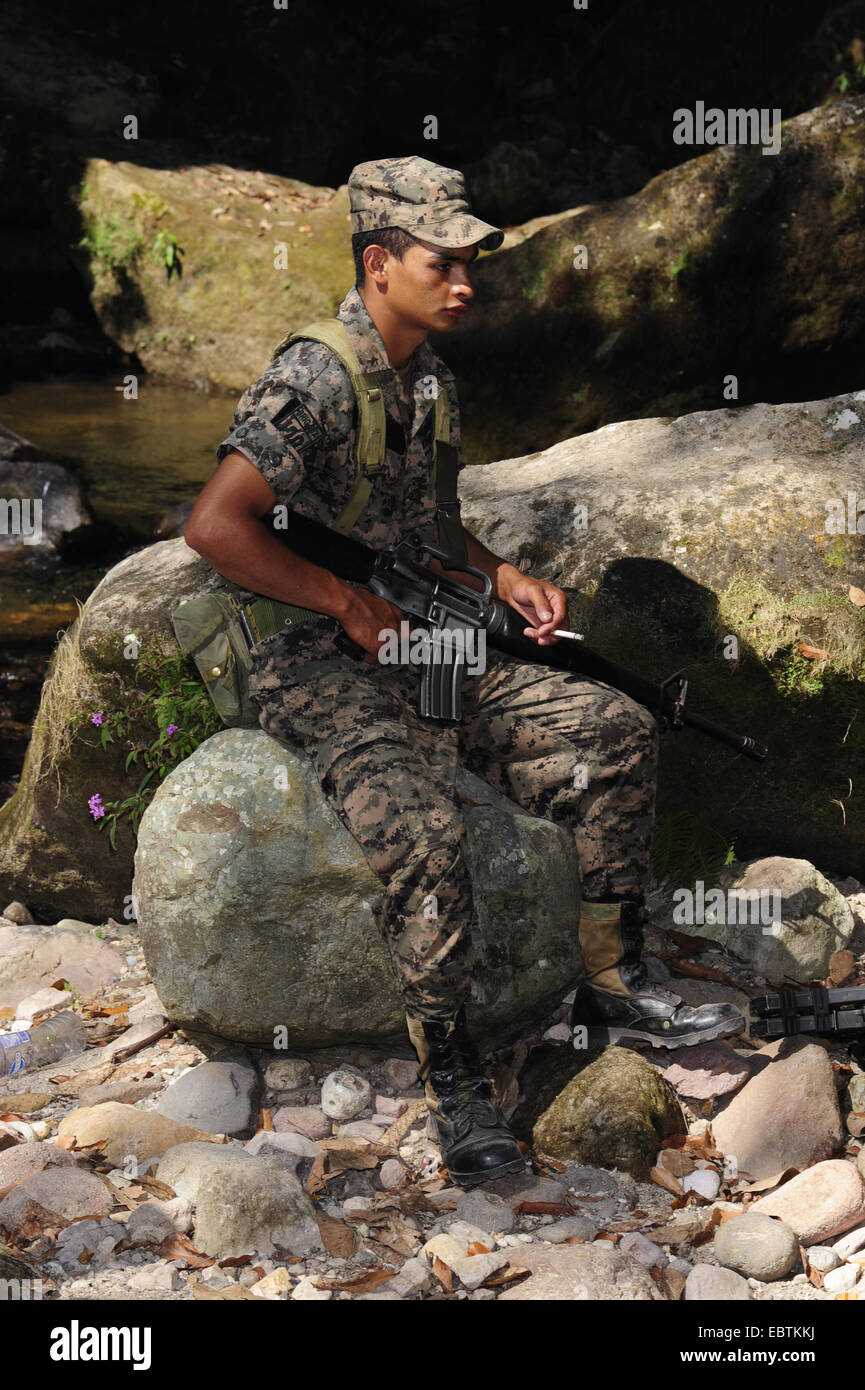 Soldato sittind fumare su una roccia , Honduras, Copan Foto Stock