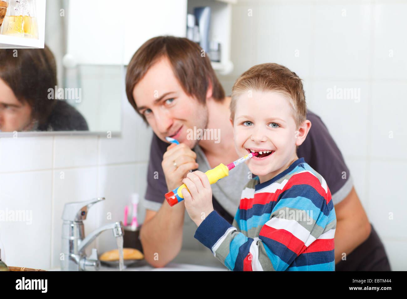 Padre e figlio lavarsi i denti insieme Foto Stock