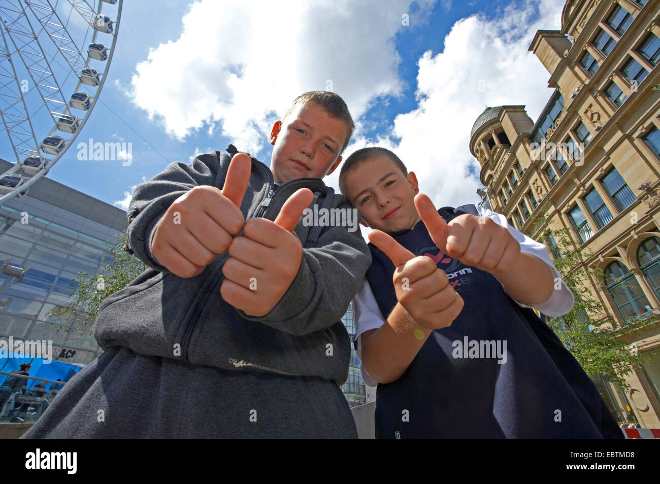 Due giovani ragazzi nel centro città alzando i pollici, Regno Unito, Inghilterra, Manchester Foto Stock
