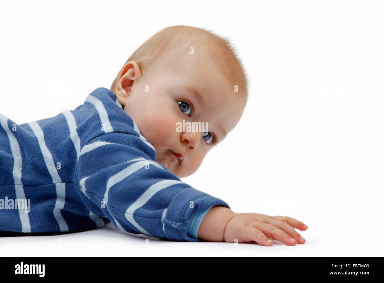 Curioso baby in romper giacente a terra Foto Stock