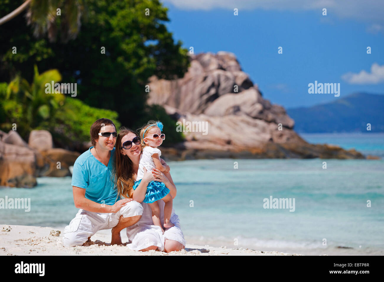 Felice giovane famiglia sulla spiaggia tropicale, Seicelle Foto Stock