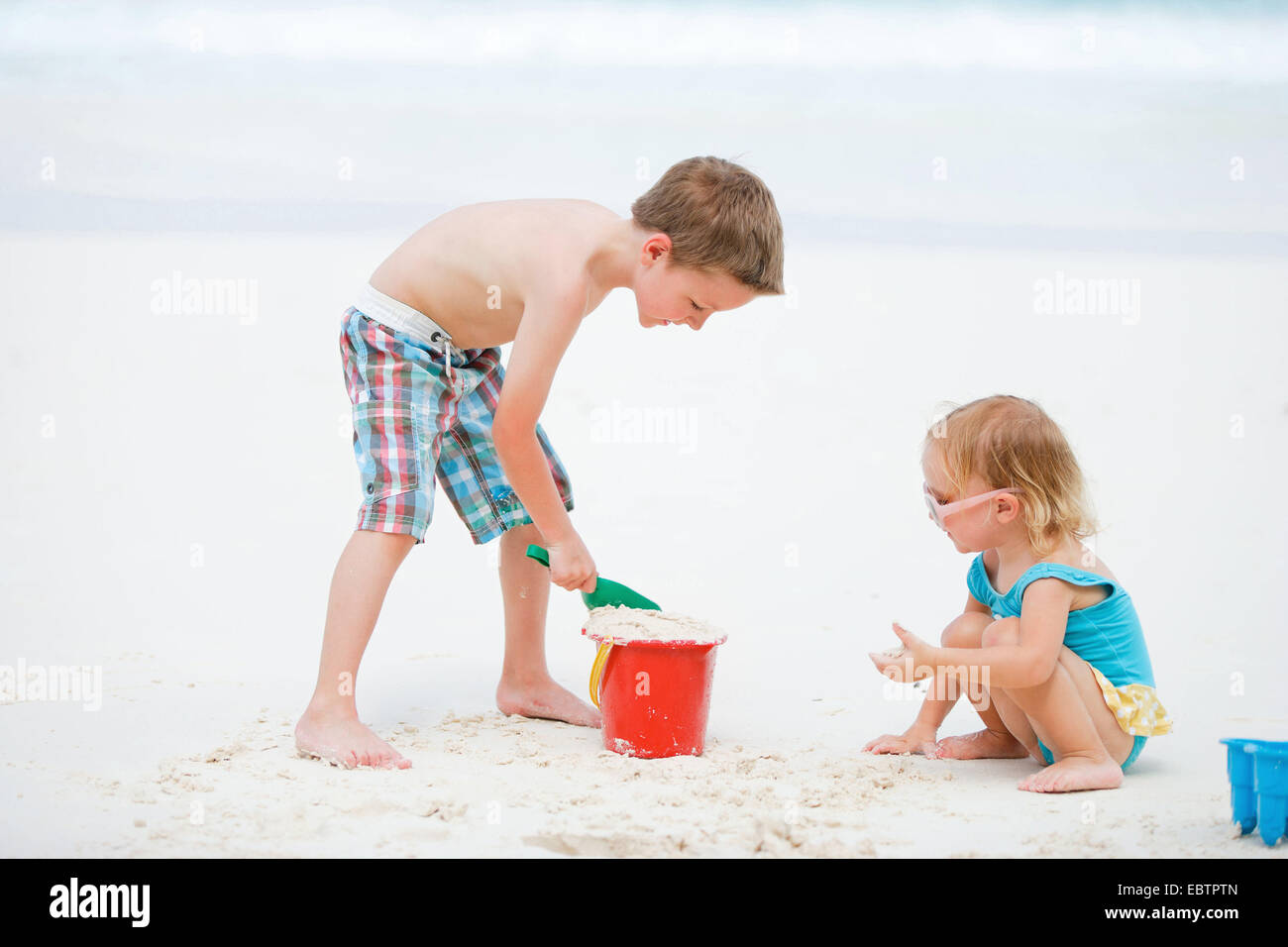 Fratello e Sorella insieme giocando sulla spiaggia sabbiosa tropicale Foto Stock