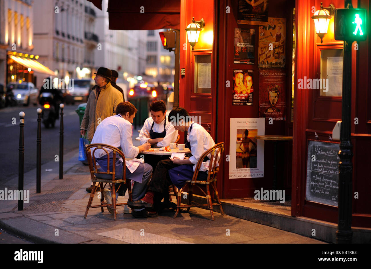 Il personale della cucina seduti ad un tavolo insieme davanti a un ristorante a Marais e il quartiere ebraico, Francia, Borgo San Paolo, Parigi Foto Stock