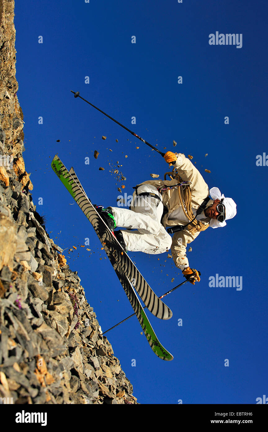 Sciatore freeride dissimulata come oldfashioned avventuriero in discesa sul pendio roccioso Foto Stock