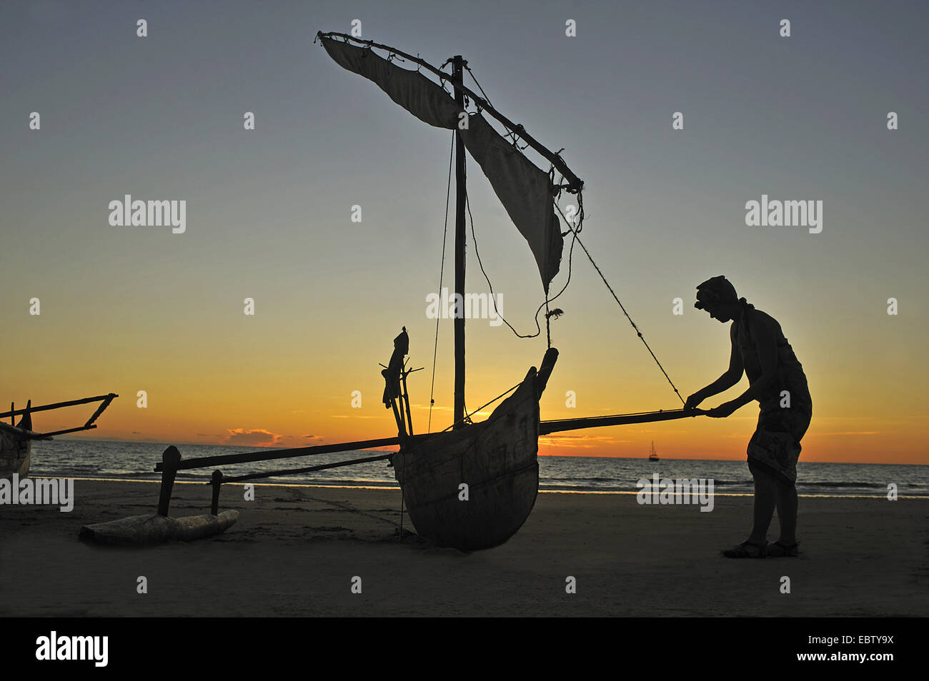 Outrigger Canoe sulla spiaggia al tramonto, Madagascar, Nosy Be Foto Stock