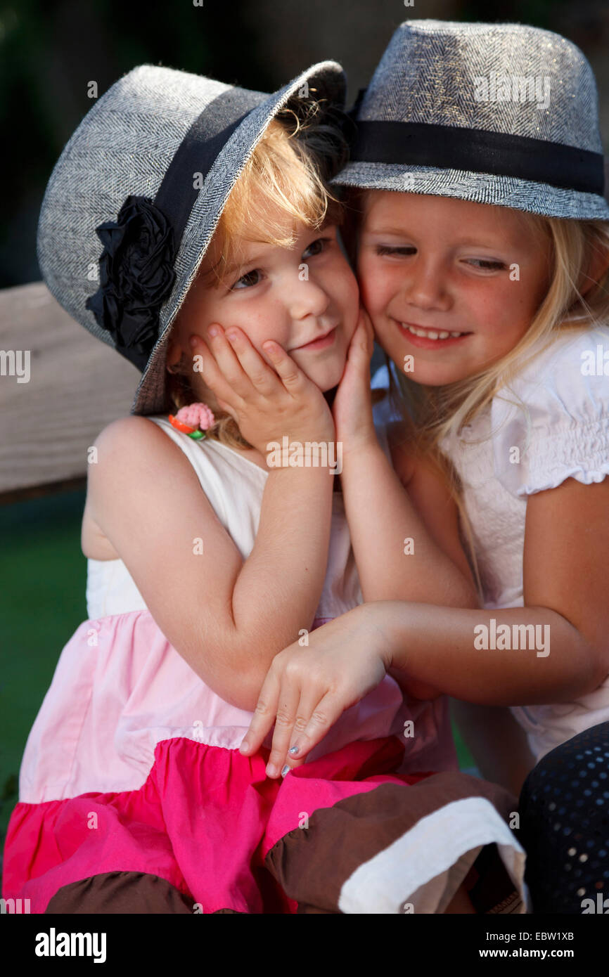 Due bambine con cappelli cuddling insieme Foto stock - Alamy