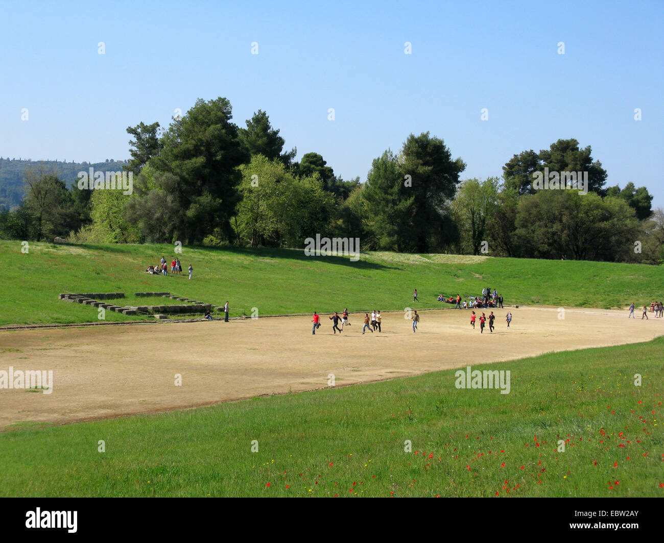 I turisti in esecuzione in antico stadio di Olympia, Grecia, Peloponnes, Olympia Foto Stock
