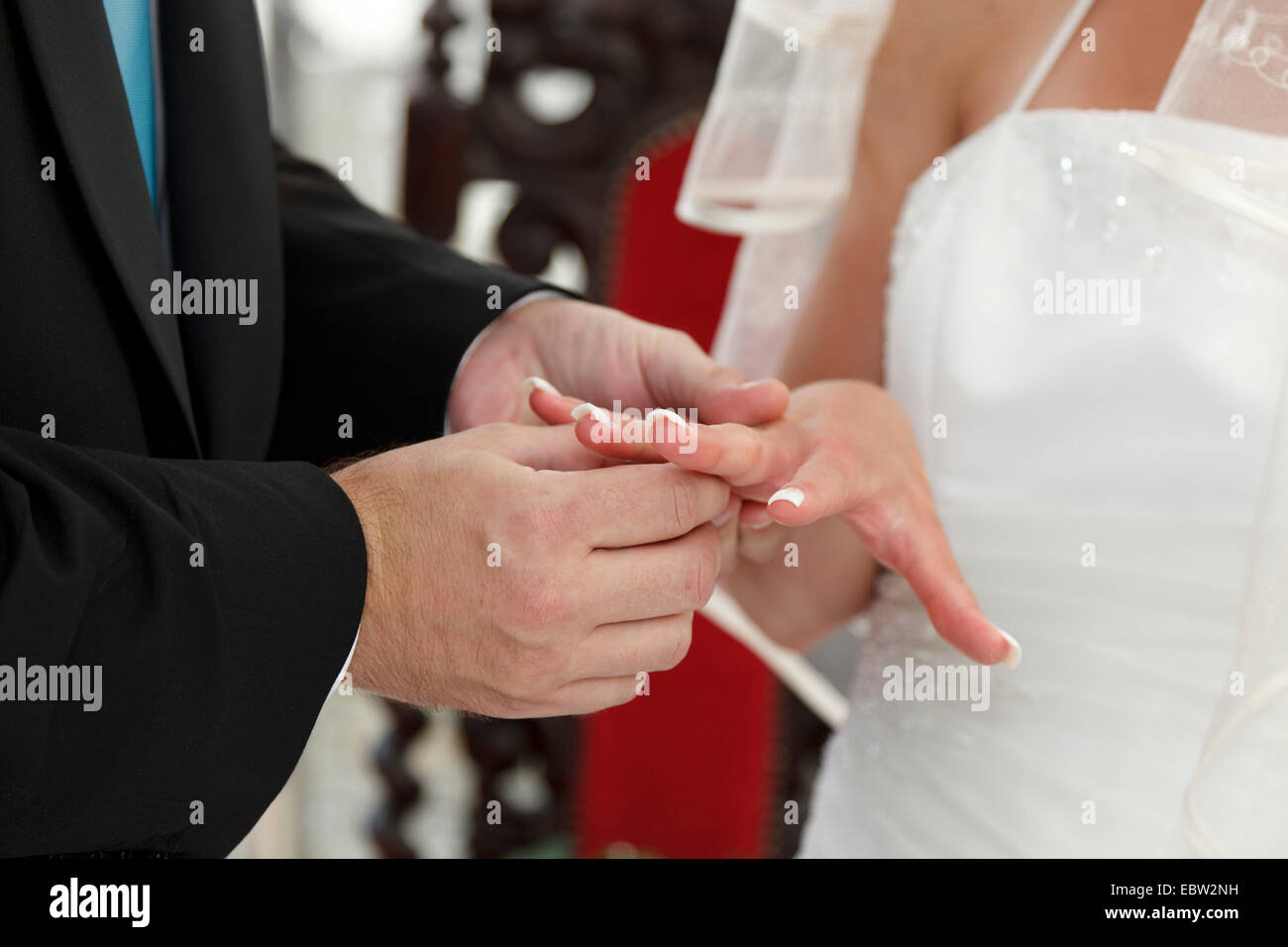 Sposo di mettere l'anello nuziale sul dito spose Foto Stock