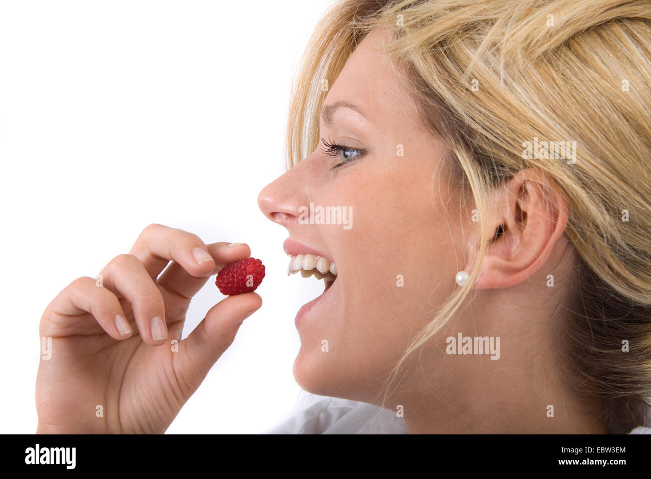 Giovane donna bionda di mangiare un lampone Foto Stock