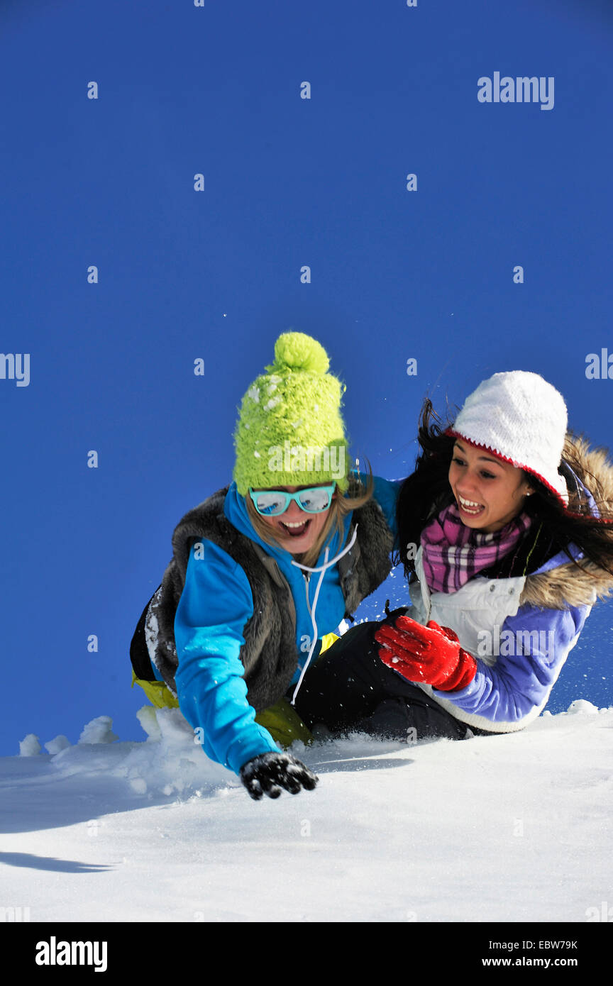 Due giovani ragazze frolicly ingannare intorno nella neve, Francia Foto Stock