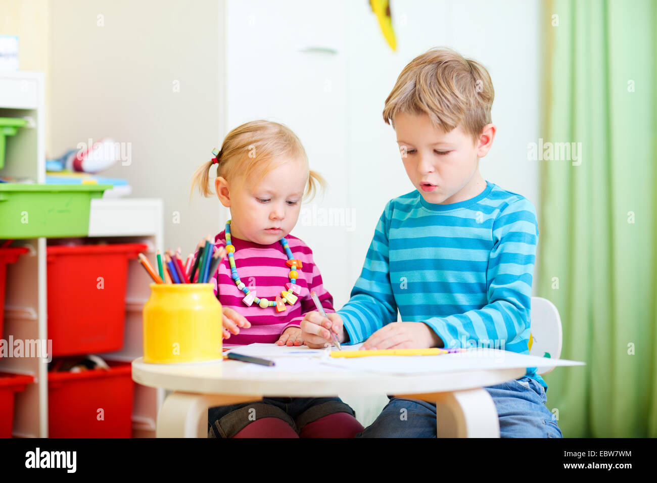 Una ragazza giovane e suo fratello il disegno nella scuola materna Foto Stock
