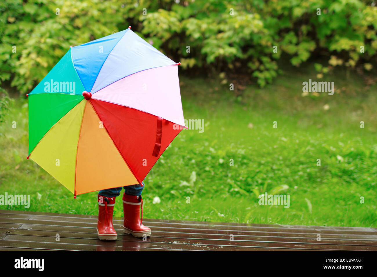 Bambina nascosto dietro un ombrello Foto Stock