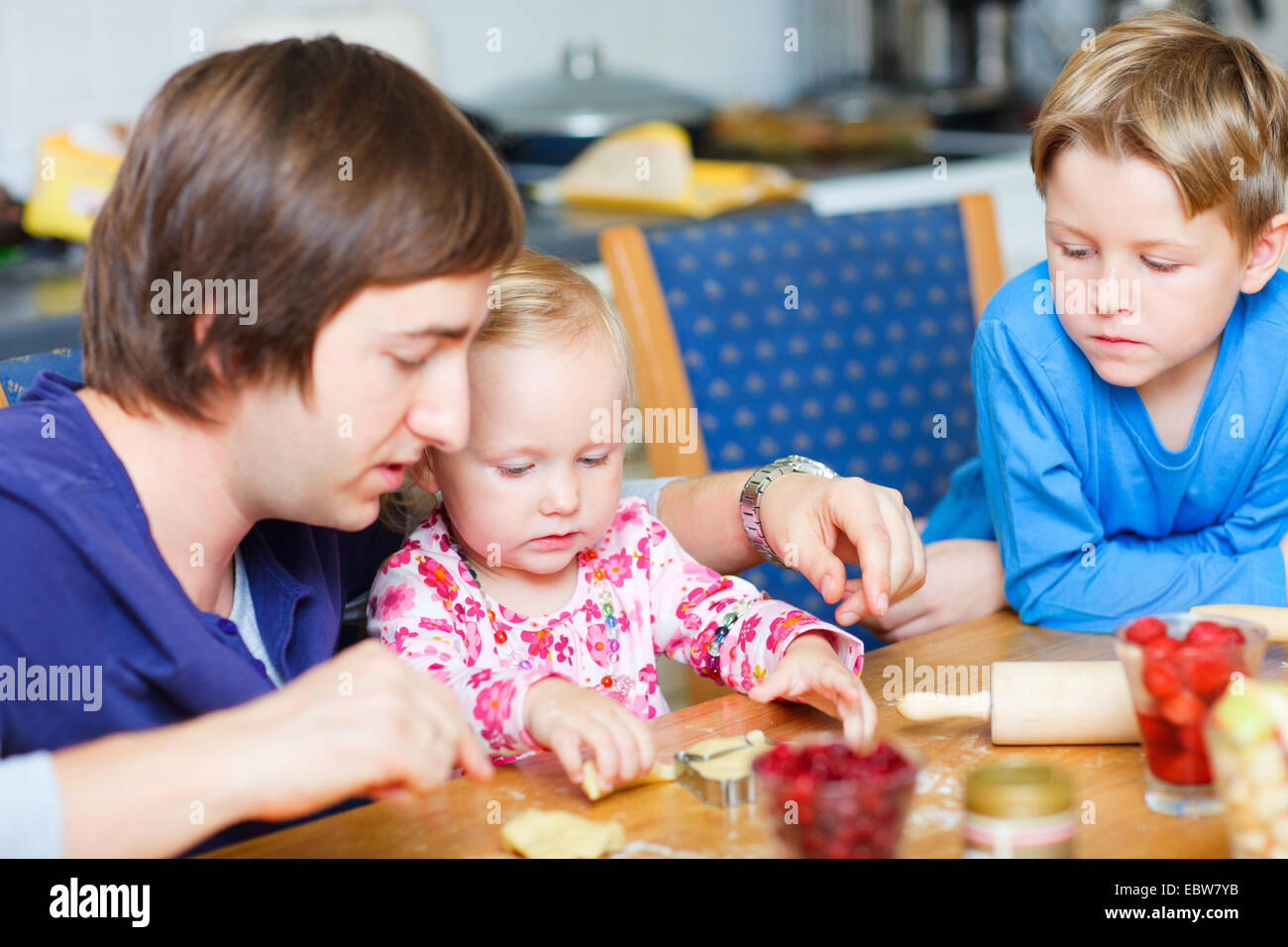 Padre e i suoi due bambini piccoli biscotti di cottura Foto Stock