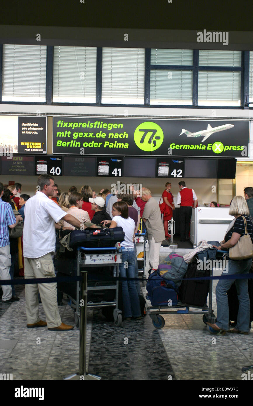 Persone in corrispondenza di un banco ricevimento presso l'aeroporto Foto Stock