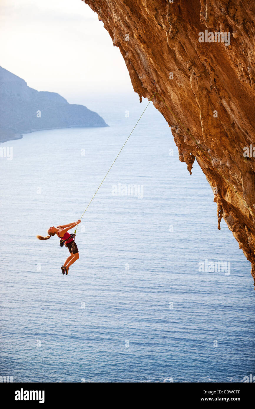 Female Rock scalatore la caduta di una scogliera mentre arrampicata di piombo Foto Stock