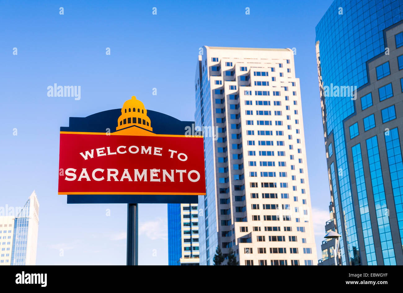 Un 'Benvenuti al sacramento " segno nel centro di Sacramento, con grattacieli (non in piano di una messa a fuoco nitida). Foto Stock