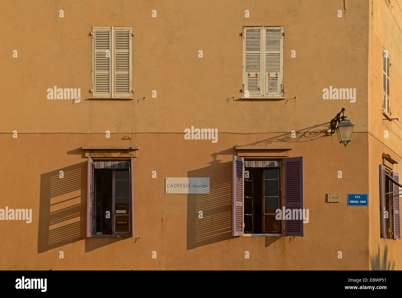 Una facciata in Ajaccio con aperto e chiuso windows illuminata dalla calda luce del mattino. Ajaccio è la capitale del mediterraneo Foto Stock