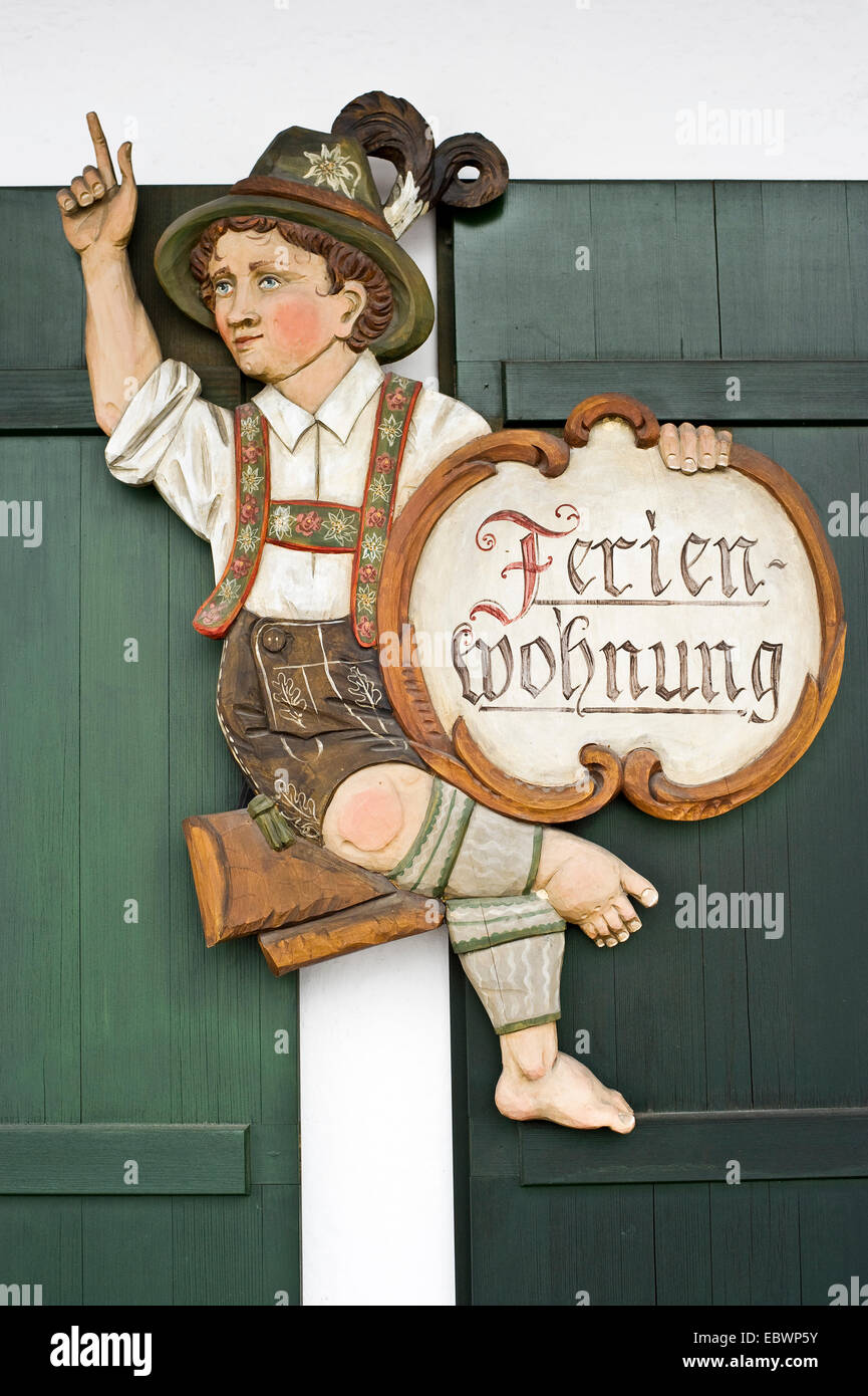 In legno intagliato figura con un segno "Ferienwohnung', il tedesco di casa vacanze, Garmisch-Partenkirchen, Alta Baviera, Baviera Foto Stock