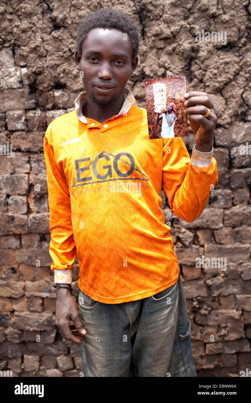 Orgoglioso giovane uomo che mostra una foto di sé, Burundi, Karuzi, Buhiga Foto Stock