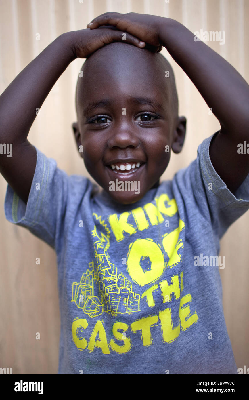 Ritratto di un ragazzino felicemente presentando la sua T-shirt con il wrighting "Re di Castello', Burundi Bujumbura Mairie, Bujumbura Foto Stock