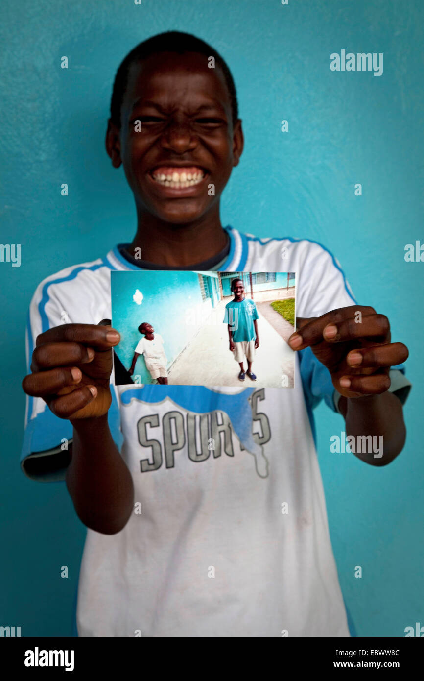 Ragazzo di ridere mentre mostra una foto con un amico e lui su di esso, il Burundi Bujumbura Mairie, Bujumbura Foto Stock