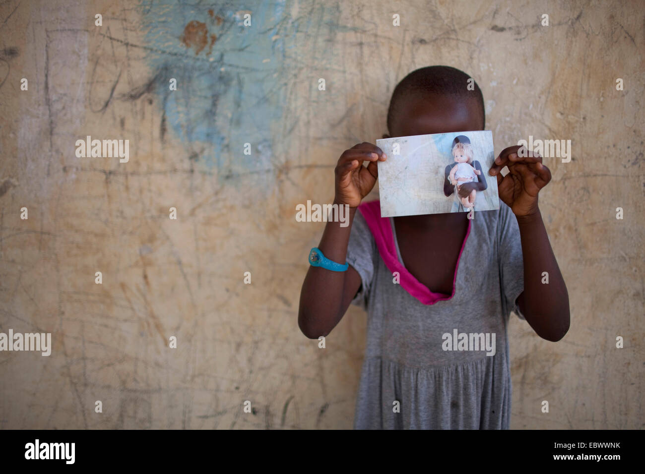 Bambina che mostra una foto dove ella tenendo una bambola, Burundi Bujumbura Mairie, Bujumbura Foto Stock